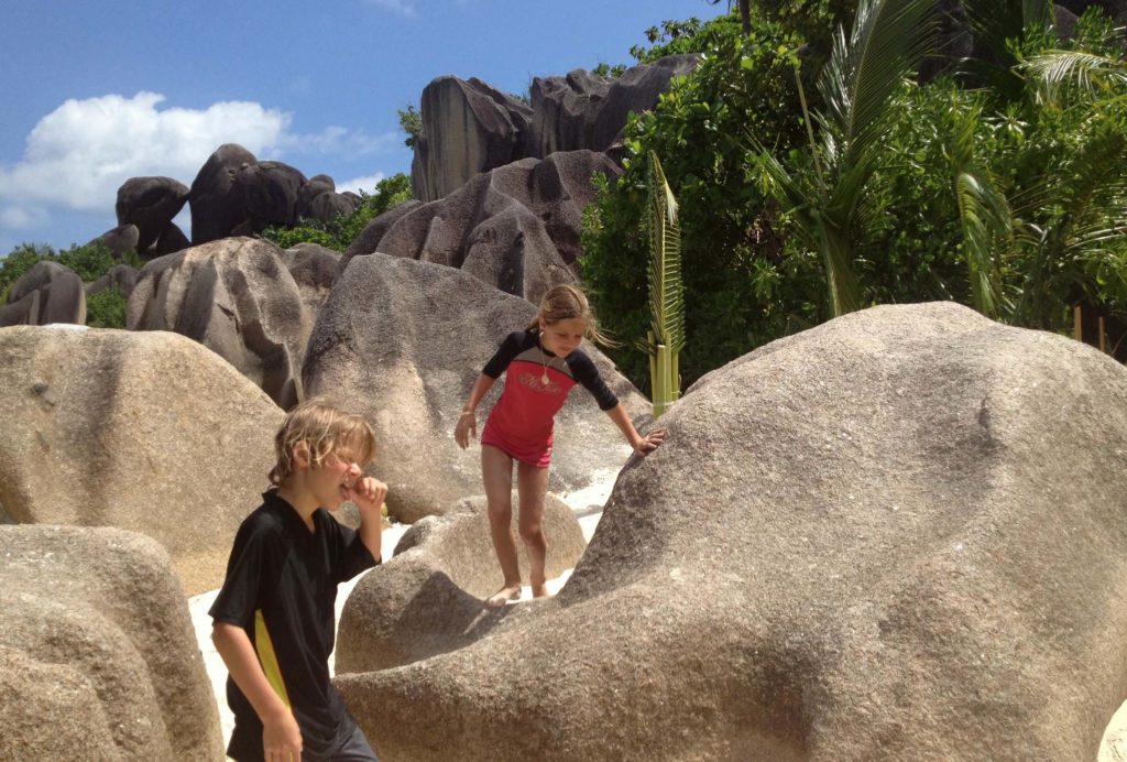 Verstoppertje spelen tussen de rotsen op de Seychellen met kinderen